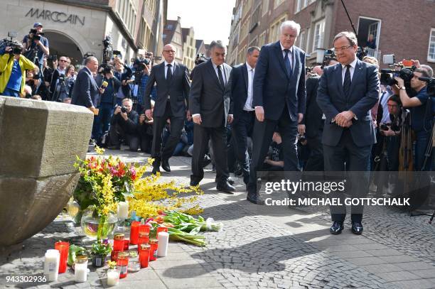German Interior Minister Horst Seehofer and State leader in North Rhine-Westphalia Armin Laschet pay their respect at a makeshift memorial at the...