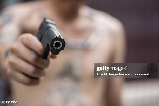 young man took aim with pistol near village roads. - assassination stock pictures, royalty-free photos & images