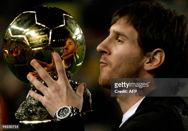 Barcelona's Argentinian forward Lionel Messi poses with his trophy of European footballer of the year award, the "Ballon d'Or" , before the Spanish...