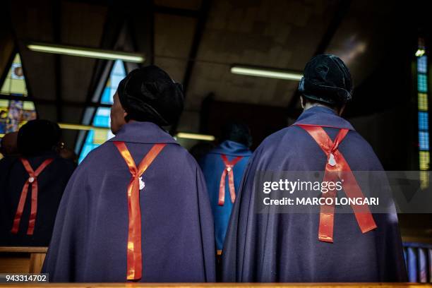 Congregants of the catholic St. Anna group pray during a Sunday service at the iconic Regina Mundi Church in Soweto, Johannesburg, on April 8, 2018....