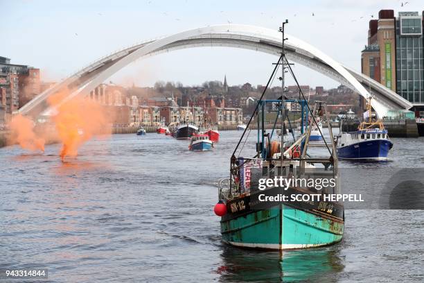 Flotilla of fishing vessels passes under the Millennium Bridge in Newcastle, northeast England on April 8 during a protest against the Brexit...