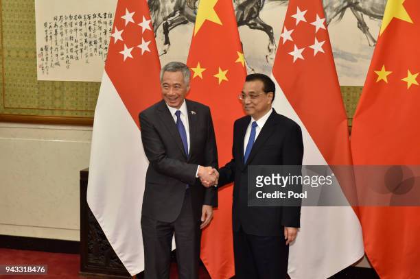 Chinese Premier Li Keqiang, shakes hands with Singapore's Prime Minister Lee Hsien Loong during a signing ceremony on April 8, 2018 at the Diaoyutai...