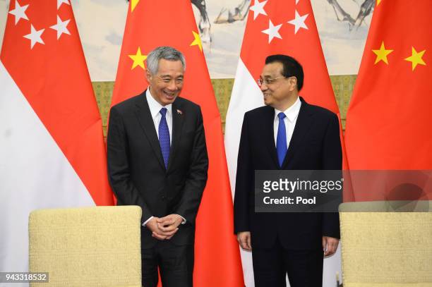 Chinese Premier Li Keqiang, stands next to with Singapore's Prime Minister Lee Hsien Loong during a signing ceremony on April 8, 2018 at the...