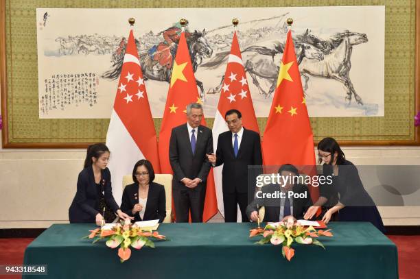 Chinese Premier Li Keqiang, talks with Singapore's Prime Minister Lee Hsien Loong during a signing ceremony on April 8, 2018 at the Diaoyutai State...