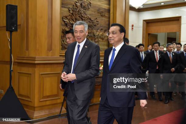Chinese Premier Li Keqiang, walks with Singapore's Prime Minister Lee Hsien Loong, after a signing ceremony on April 8, 2018 at the Diaoyutai State...