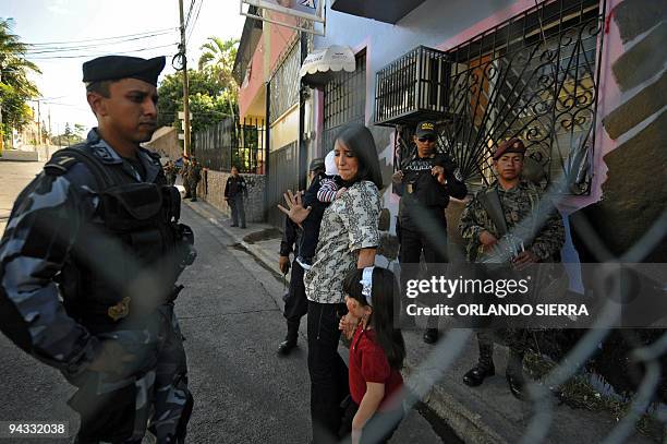 Honduran deposed President Manuel Zelaya's daughter Zoe Zelaya with her children Juan Manuel and Irene, walks next to soldiers and policemen towards...