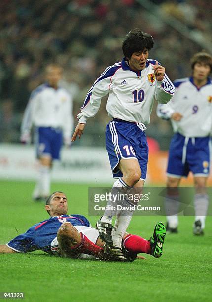 Hiroshi Nanami of Japan is tackled by Sabri Lamouchi of France during the International Friendly match played at the Stade De France, in Paris,...