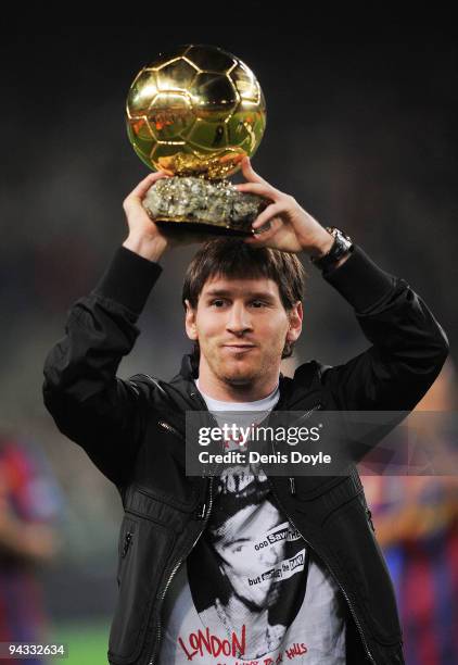 Lionel Messi holds up his European footballer of the year award, the 'Ballon d'Or' , before the La Liga match between Barcelona and Espanyol at the...