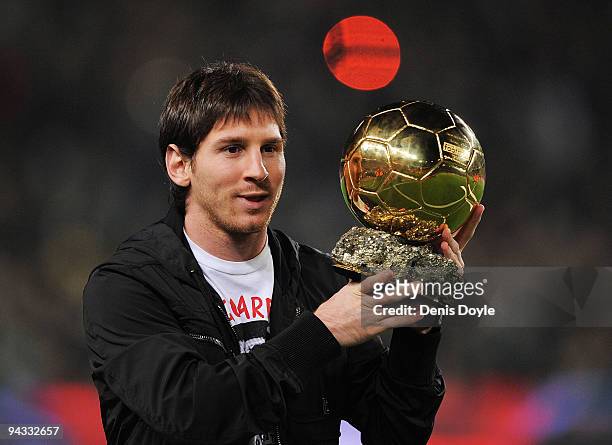 Lionel Messi holds up his European footballer of the year award, the 'Ballon d'Or' , before the La Liga match between Barcelona and Espanyol at the...