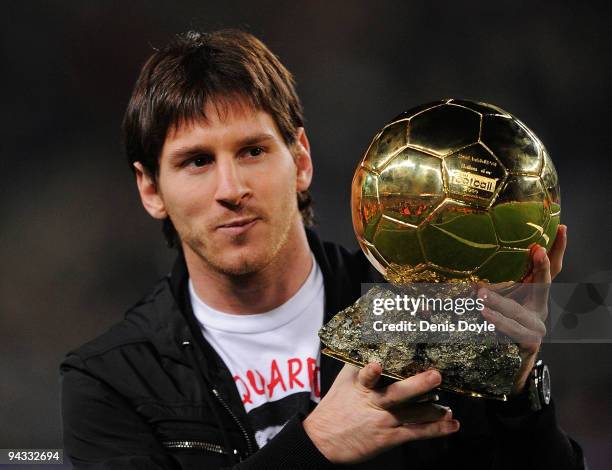 Lionel Messi holds up his European footballer of the year award, the 'Ballon d'Or' , before the La Liga match between Barcelona and Espanyol at the...