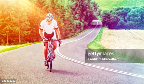 athlet mit entschlossenheit fahrradtouren professionelle rennen auf einem hügel - mikkelwilliam stock-fotos und bilder