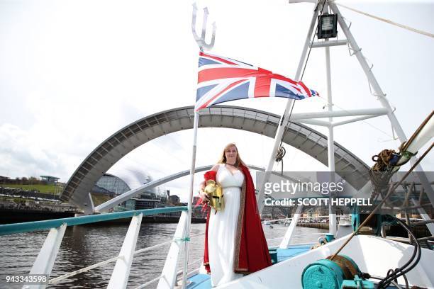 Woman dressed as Britannia, poses on deck as a flotilla of fishing vessels passes under the Millennium Bridge in Newcastle, northeast England on...
