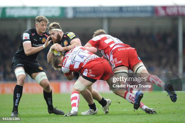 Luke Cowan-Dickie of Exeter Chiefs is tackled by Tom Savage and Ed Salter of Gloucester during the Aviva Premiership match between Exeter Chiefs and...