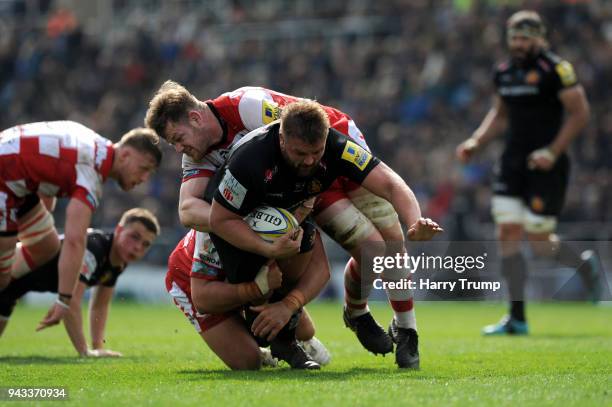 Tomas Francis of Exeter Chiefs is tackled by Josh Hohneck and Tom Savage of Gloucester during the Aviva Premiership match between Exeter Chiefs and...