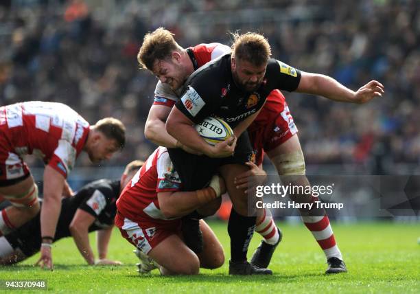 Tomas Francis of Exeter Chiefs is tackled by Josh Hohneck and Tom Savage of Gloucester during the Aviva Premiership match between Exeter Chiefs and...