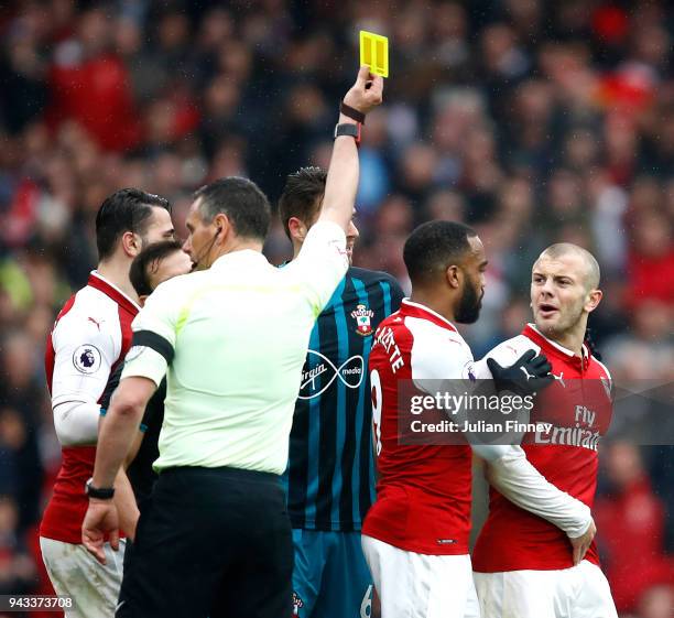 Jack Wilshere of Arsenal is shown a yellow card by referee Andre Marriner during the Premier League match between Arsenal and Southampton at Emirates...