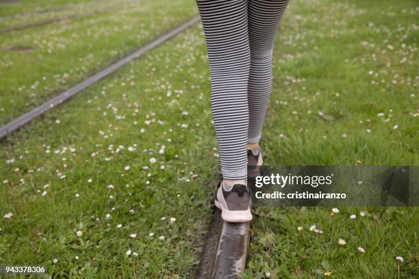 little girl walking on the tracks of a tram - printemps fun flower stock-fotos und bilder