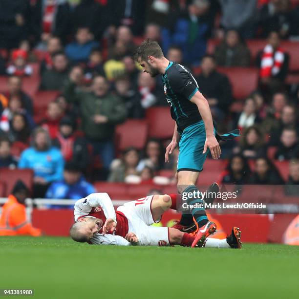 Jack Wilshere of Arsenal goes down after Jack Stephens of Southampton had swung an arm in his direction during the Premier League match between...