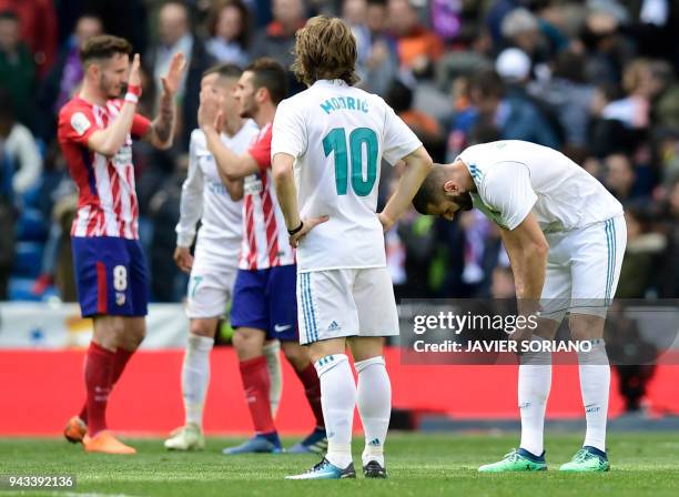 Real Madrid's Croatian midfielder Luka Modric looks at Atletico players celebrating their victory at the end of the Spanish league football match...