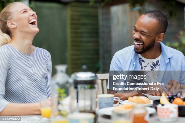 laughing couple having breakfast on patio - coffee on patio stock pictures, royalty-free photos & images