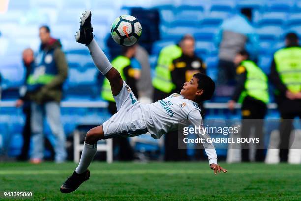 Cristiano Jr, son of Real Madrid's Portuguese forward Cristiano Ronaldo, kicks a ball at the end of the Spanish league football match between Real...