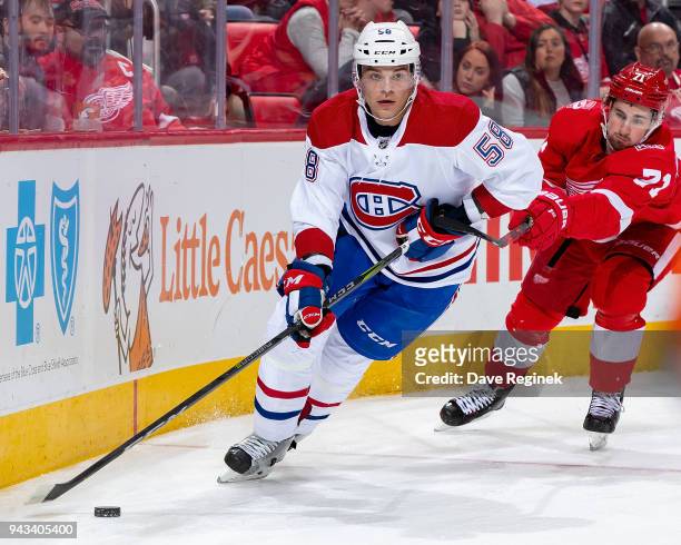 Noah Juulsen of the Montreal Canadiens skates around the net with the puck in front of Dylan Larkin of the Detroit Red Wings during an NHL game at...