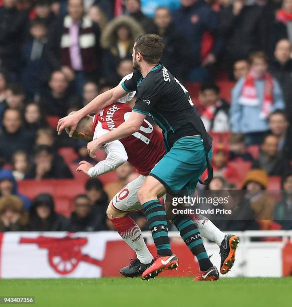 Jack Wilshere of Arsenal is shoved by Jack Stephens of Southampton during the Premier League match between Arsenal and Southampton at Emirates...