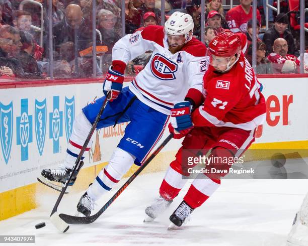 Dylan Larkin of the Detroit Red Wings battles for the puck with Jeff Petry of the Montreal Canadiens during an NHL game at Little Caesars Arena on...
