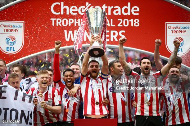 Luke Waterfall of Lincoln lifts the trophy with his teammates after victory during the Checkatrade Trophy Final between Shrewsbury Town and Lincoln...