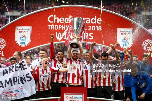 Luke Waterfall of Lincoln lifts the trophy with his teammates after victory during the Checkatrade Trophy Final between Shrewsbury Town and Lincoln...