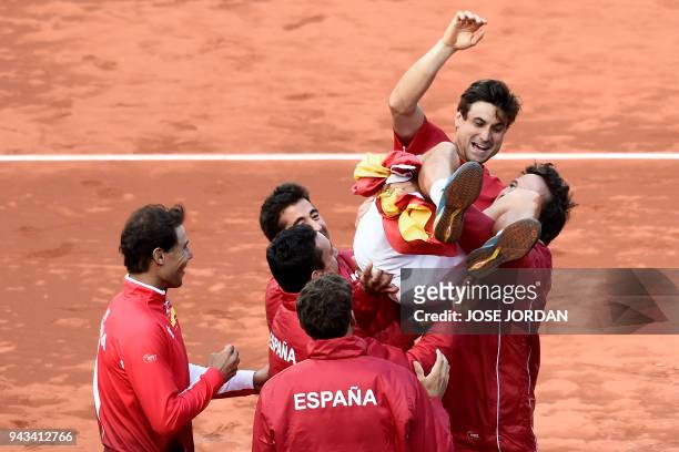 Spain's David Ferrer is carried by teammates as they celebrate after beating Germany during the Davis Cup quarter-final tennis match at the bullring...