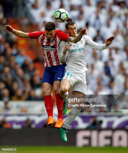 Gareth Bale of Real Madrid competes for the ball with Saul Ñiguez of Atletico de Madrid during the La Liga match between Real Madrid and Atletico de...