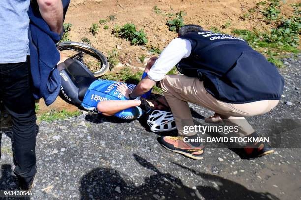 Belgium's Michael Goolaerts of Veranda's Willems-Crelan cycling team receives first aid after a crash during the 116th edition of the Paris-Roubaix...