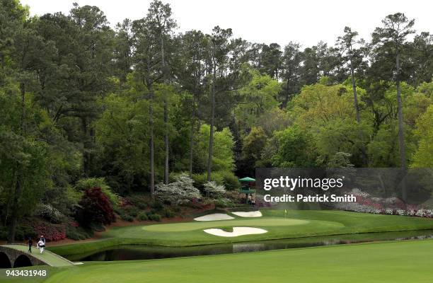 General view is seen as Tiger Woods of the United States walks over the Hogan Bridge to the 12th green during the final round of the 2018 Masters...