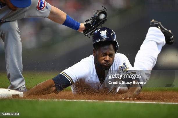 Lorenzo Cain of the Milwaukee Brewers is tagged out at first base by Victor Caratini of the Chicago Cubs during the first inning of a game at Miller...