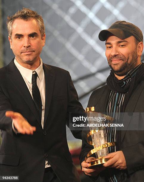 Belgium director Nabil Ben Yadir receives the jury prize for his film "Les barons" from Mexican Alfonso Cuaron at the Marrakech film festival on...