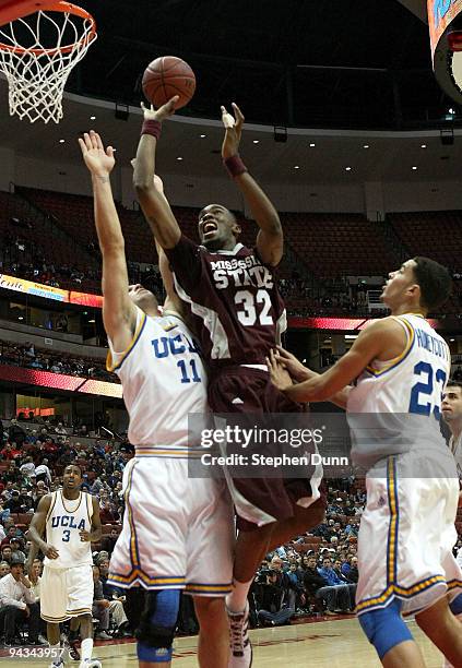 Jarvis Varnando of the Mississippi State Bulldogs shoots between Reeves Nelson and Tyler Honeycutt of the UCLA Bruins in the John Wooden Classic on...