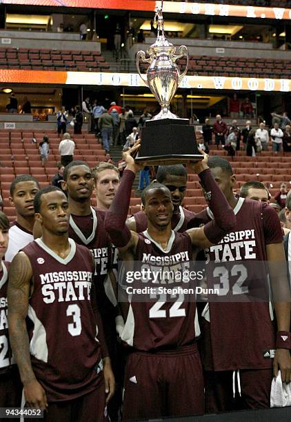 Barry Steward of the Mississippi State Bulldogs holds up the trophy with Dee Borst and Jarvis Varnando after winning their game against with the UCLA...