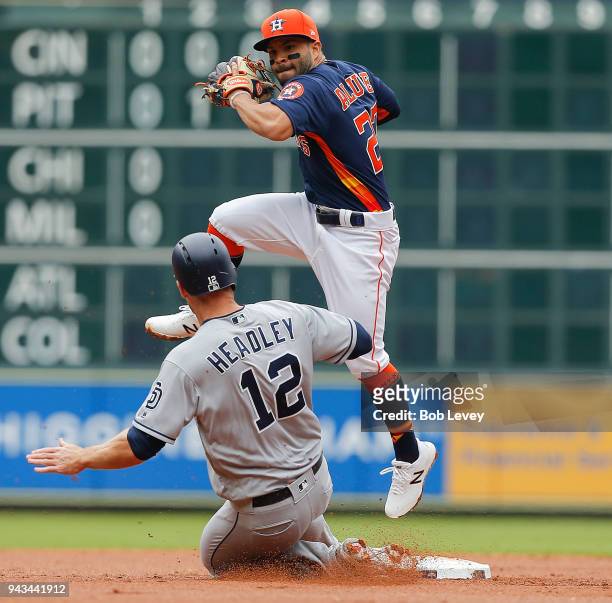Jose Altuve of the Houston Astros leaps to avoid the slide by Chase Headley of the San Diego Padres is forced out in the second inning at Minute Maid...