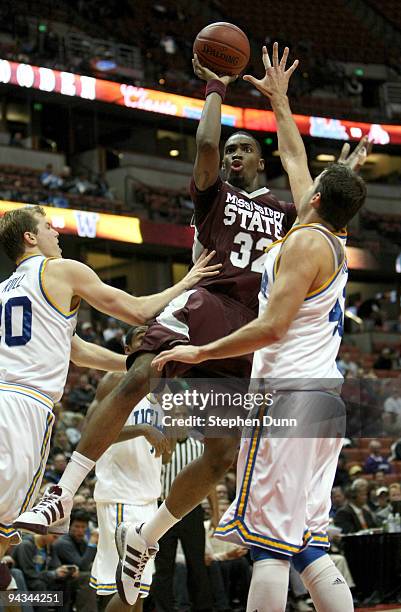 Jarvis Varnando of the Mississippi State Bulldogs shoots between Michael Roll and Nikola Dragovic of the UCLA Bruins in the John Wooden Classic on...