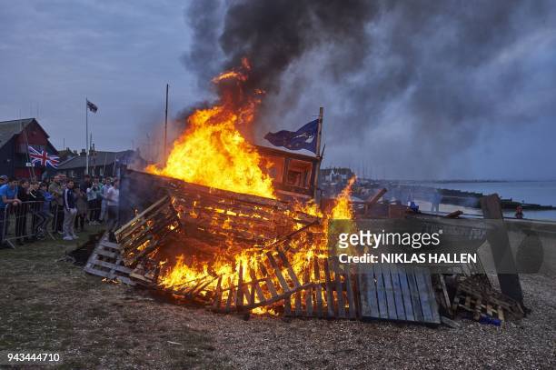 The remains of a small boat flying European flags is burnt on a bonfire during a demonstration in Whitstable, southeast England on April 8, 2018...