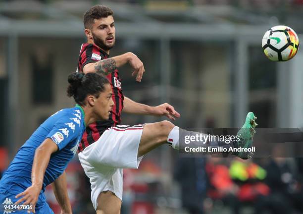 Patrick Cutrone of AC Milan is challenged by Mauricio Lemos of US Sassuolo Calcio during the serie A match between AC Milan and US Sassuolo at Stadio...