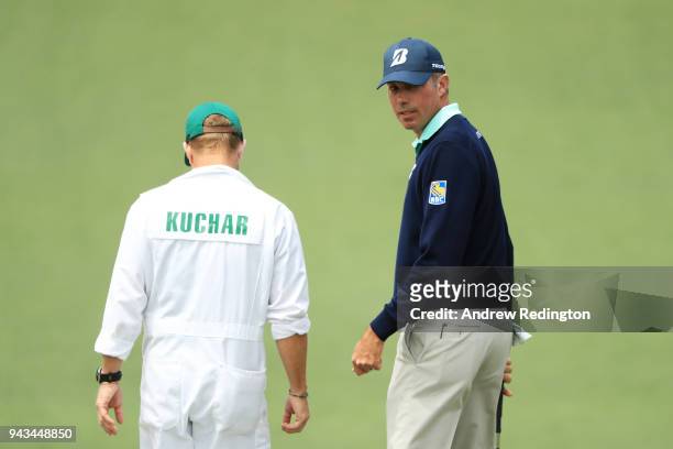 Matt Kuchar of the United States looks on as he talks with John Wood on the second hole during the final round of the 2018 Masters Tournament at...