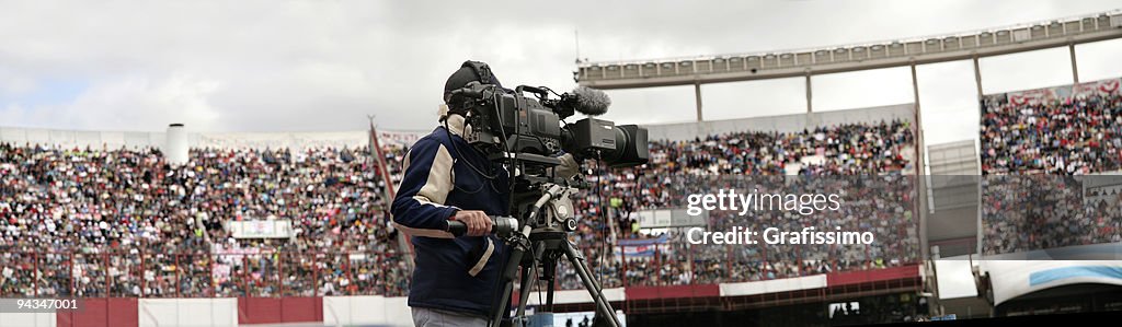 Cameraman filming in full soccer stadium