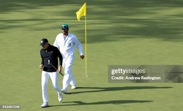 Jordan Spieth of the United States reacts to making birdie on the 15th green alongside caddie Michael Greller during the final round of the 2018...