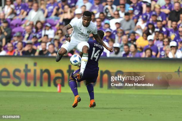 Alvas Powell of Portland Timbers leaps over Dom Dwyer of Orlando City SC during an MLS soccer match at Orlando City Stadium on April 8, 2018 in...