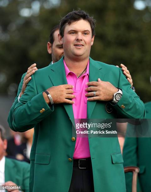 Patrick Reed of the United States is presented with the green jacket by Sergio Garcia of Spain during the Green Jacket Ceremony after winning the...