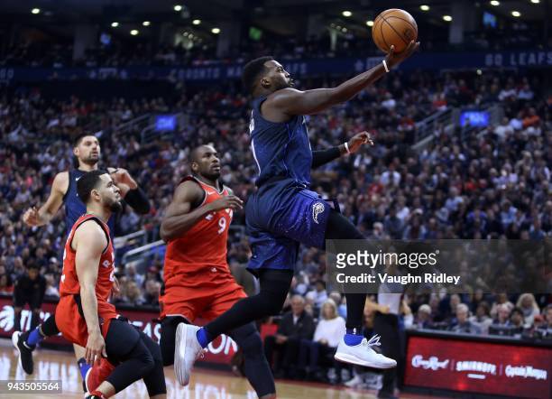 Shelvin Mack of the Orlando Magic shoots the ball as Fred VanVleet and Serge Ibaka of the Toronto Raptors defend during the first half of an NBA game...