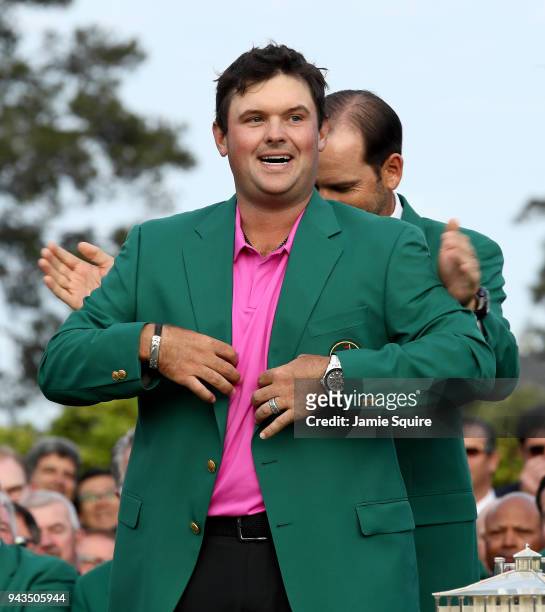 Patrick Reed of the United States is presented with the green jacket by Sergio Garcia of Spain during the green jacket ceremony after winning the...