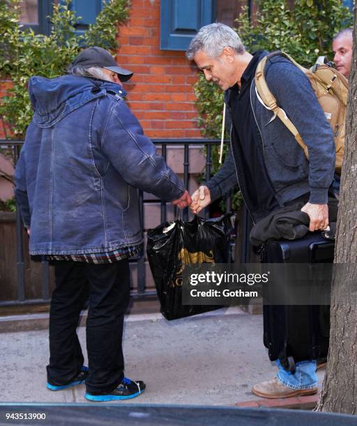 George Clooney talks to Radioman as he leaves his townhouse on April 8, 2018 in New York City.